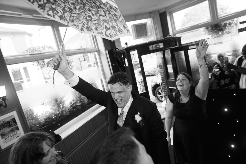 Black and white photo of guests cheering on the dance floor