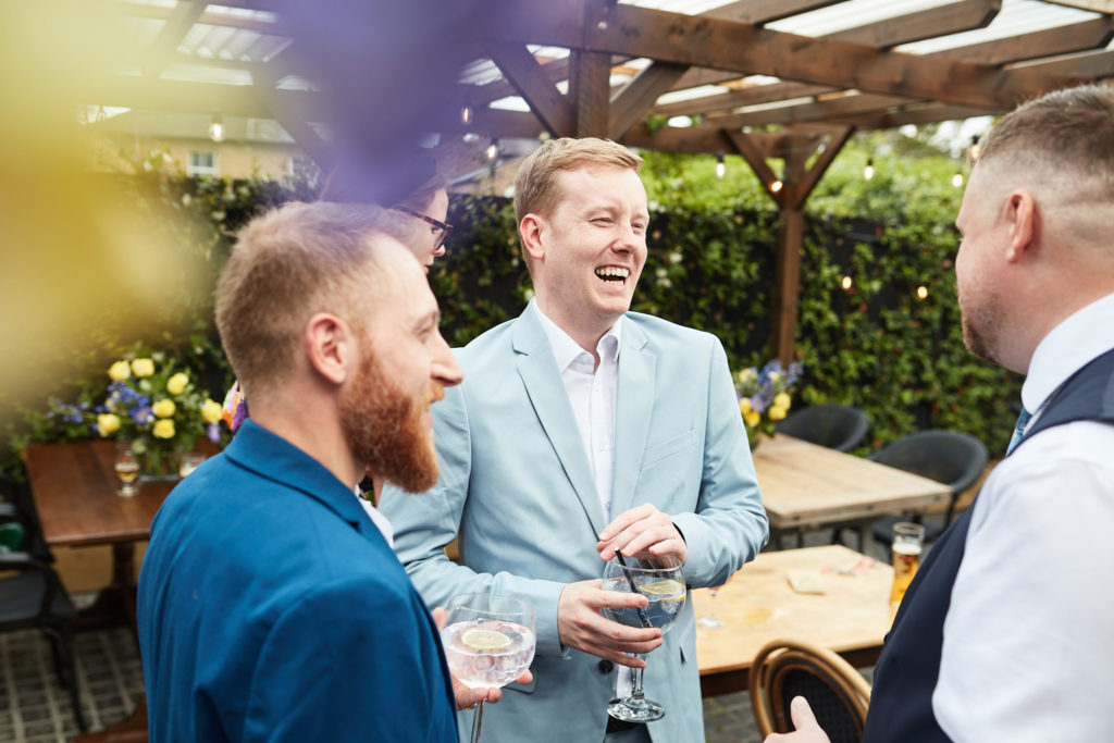Wedding guests chatting in the pub garden