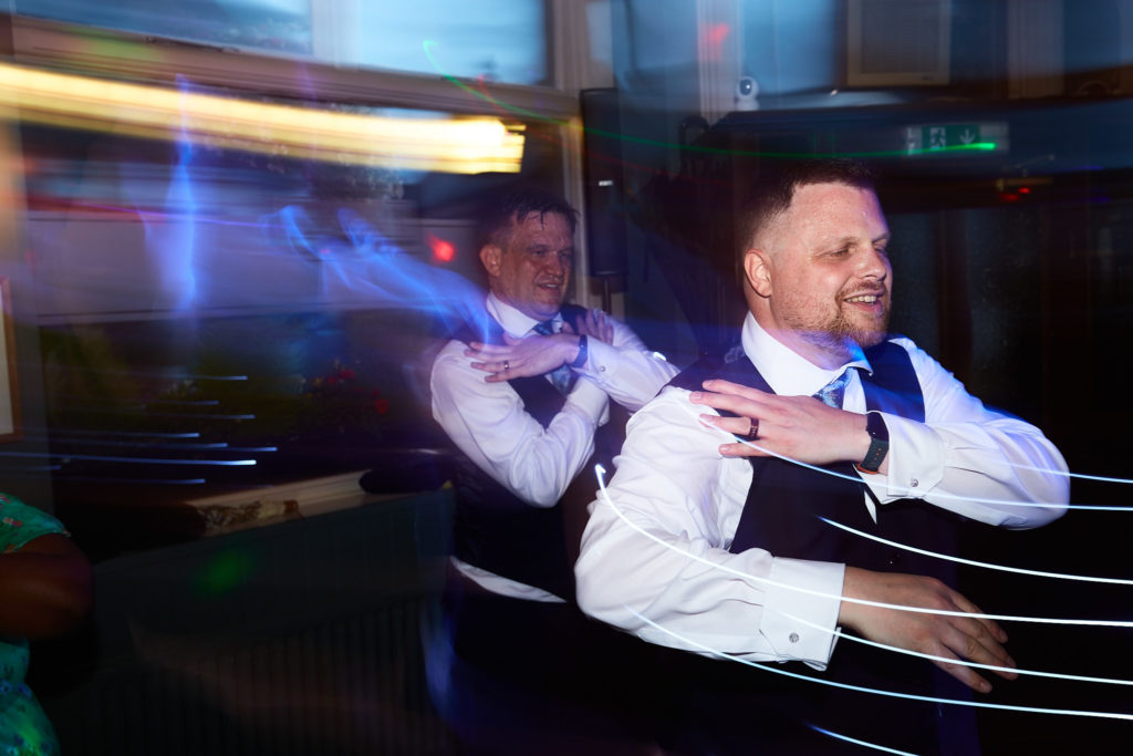 Groom dancing among streaks of light