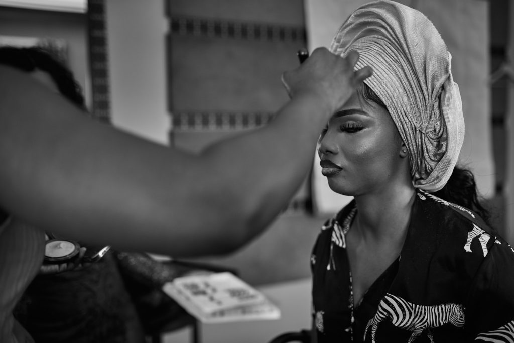 Black and white photo of the bride's head tie being adjusted as she gets ready