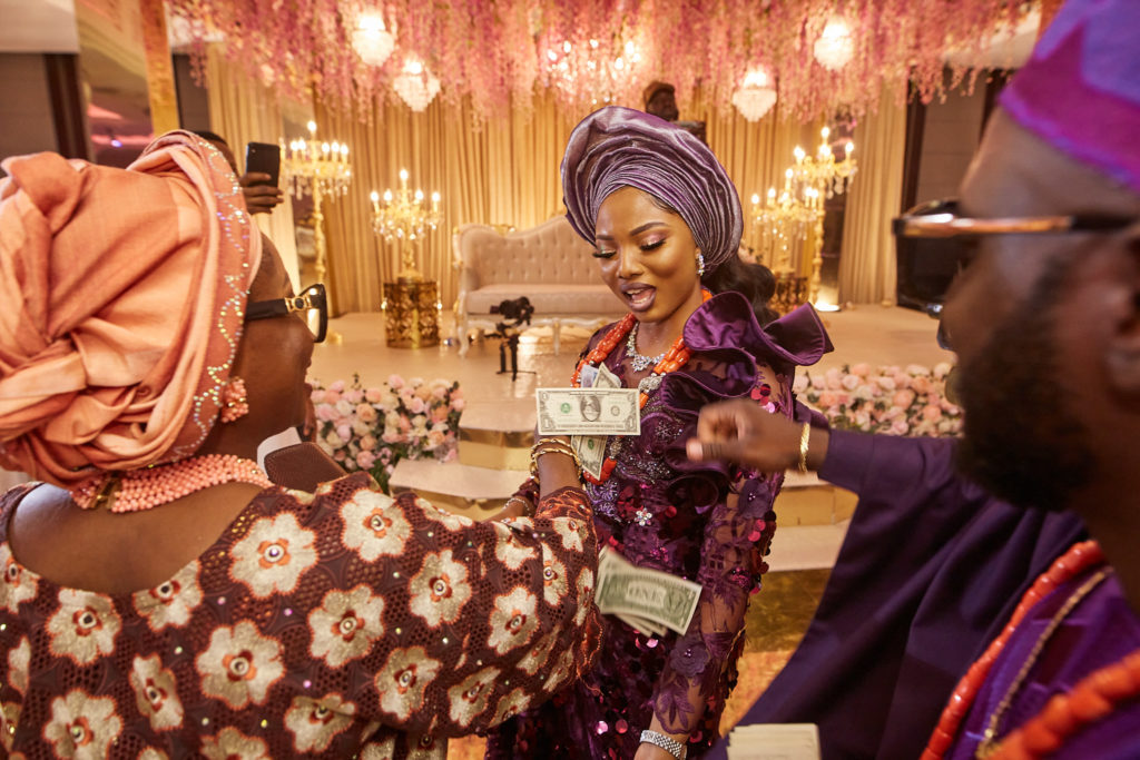 Bride in a purple outfit and silver head tie dancing with the groom