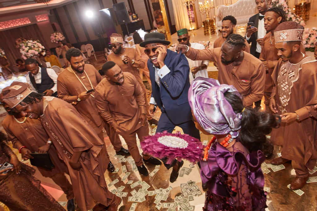 Guests gathered round the dancing bride and groom as money is sprayed