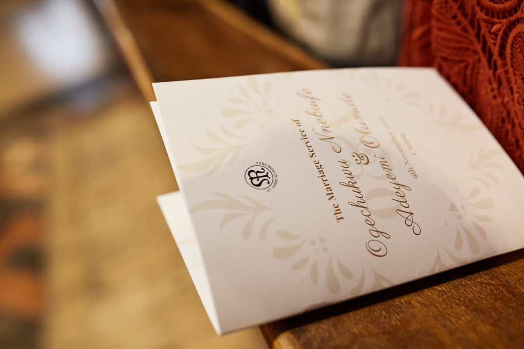 Wedding order of service on a wooden pew