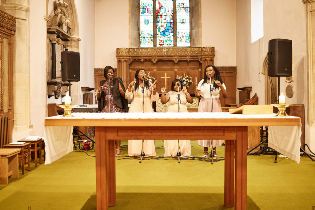 Church altar with stained glass windows and choir members gathered before the wedding