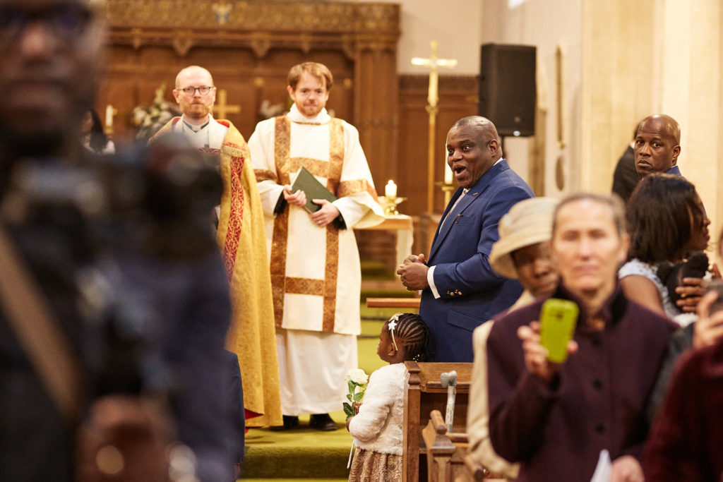 Groom smiling as the priest leads the wedding service