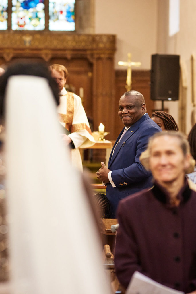 Groom smiling as the bride reaches the front of the church