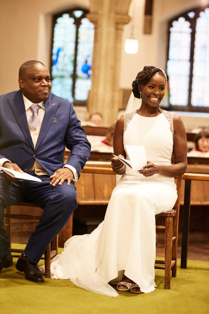 Bride smiling as she sits beside the groom during the church service