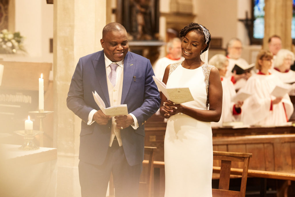 Bride and groom standing with the choir behind them