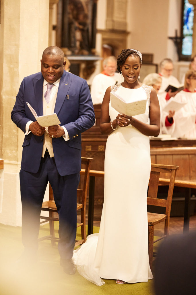 Bride and groom reading from their orders of service during the ceremony