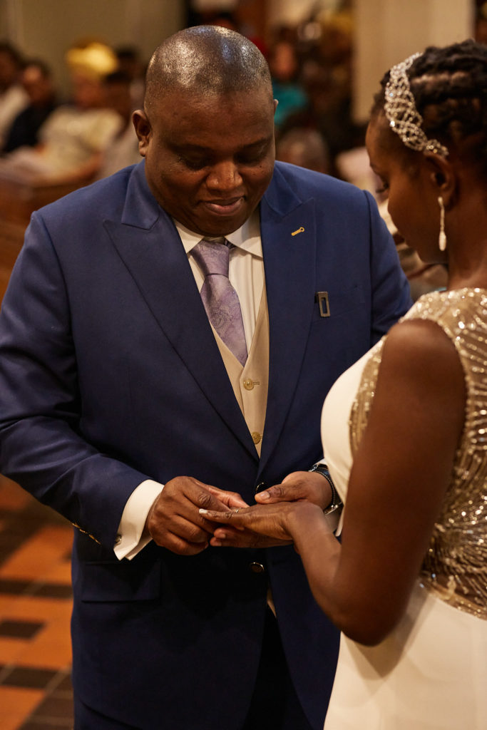 Groom placing the wedding ring on the bride's finger