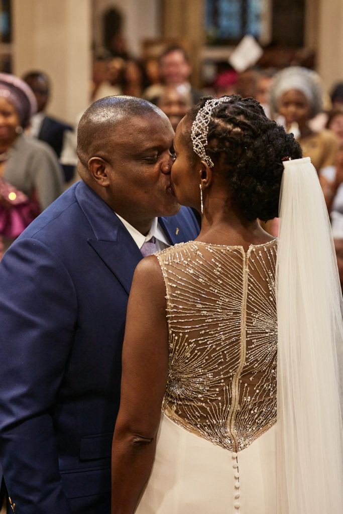 Bride and groom's first kiss, showing the beaded back of her dress