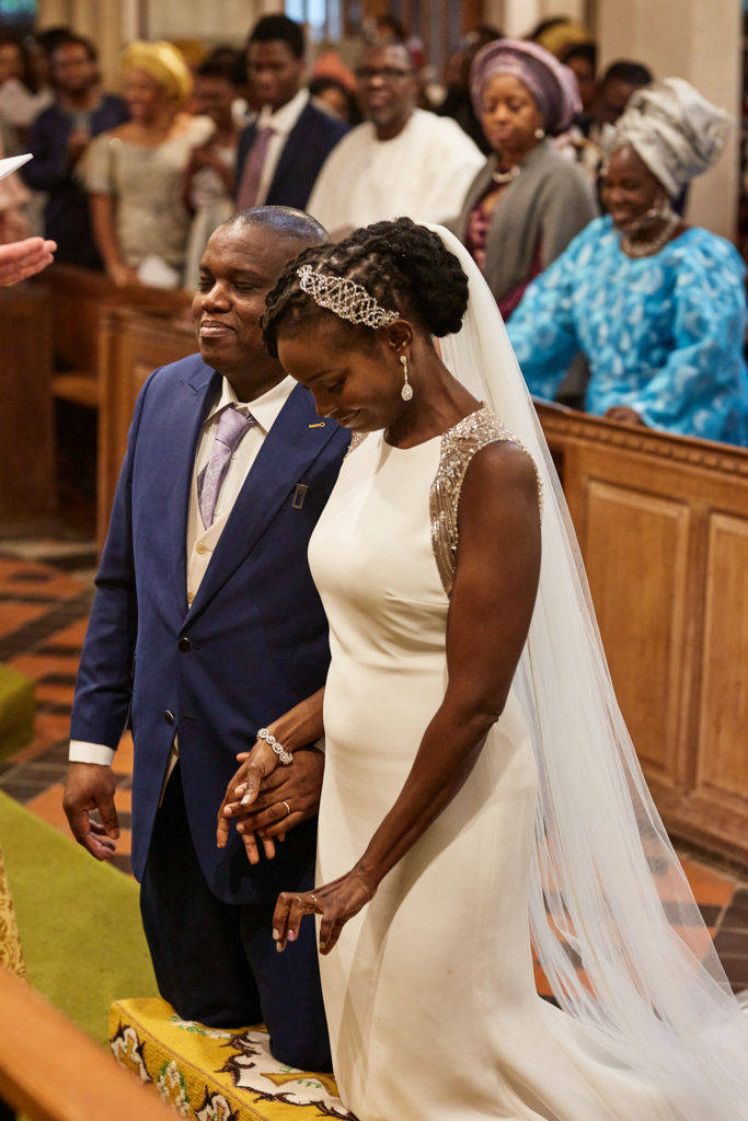 Bride and groom kneeling at the altar rail in church