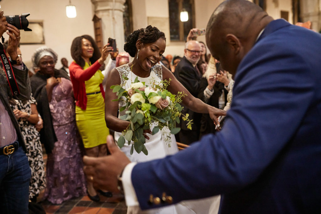 Bride laughing as guests greet her after the ceremony