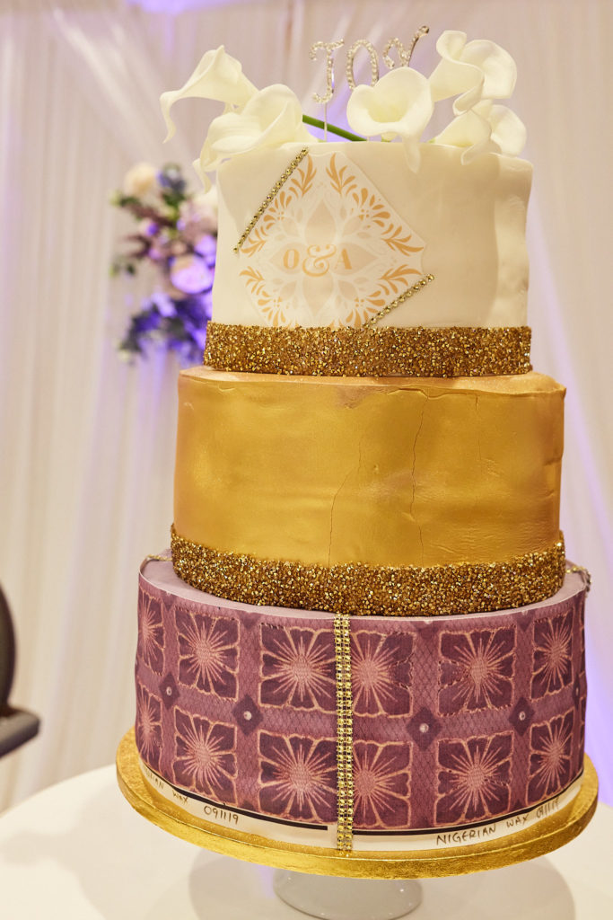 Three-tier wedding cake in white, gold and a purple African print pattern