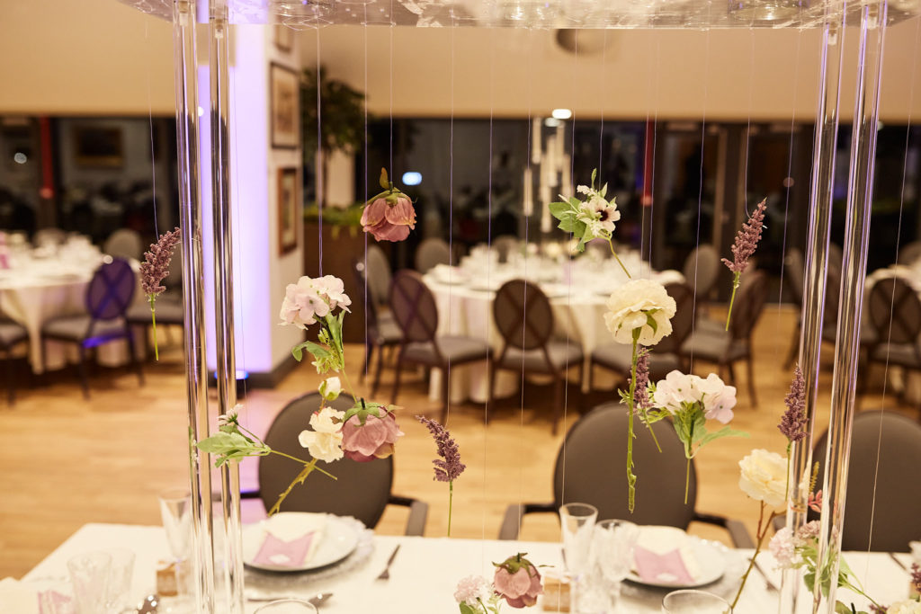 Reception room set with tall glass centrepieces and round tables