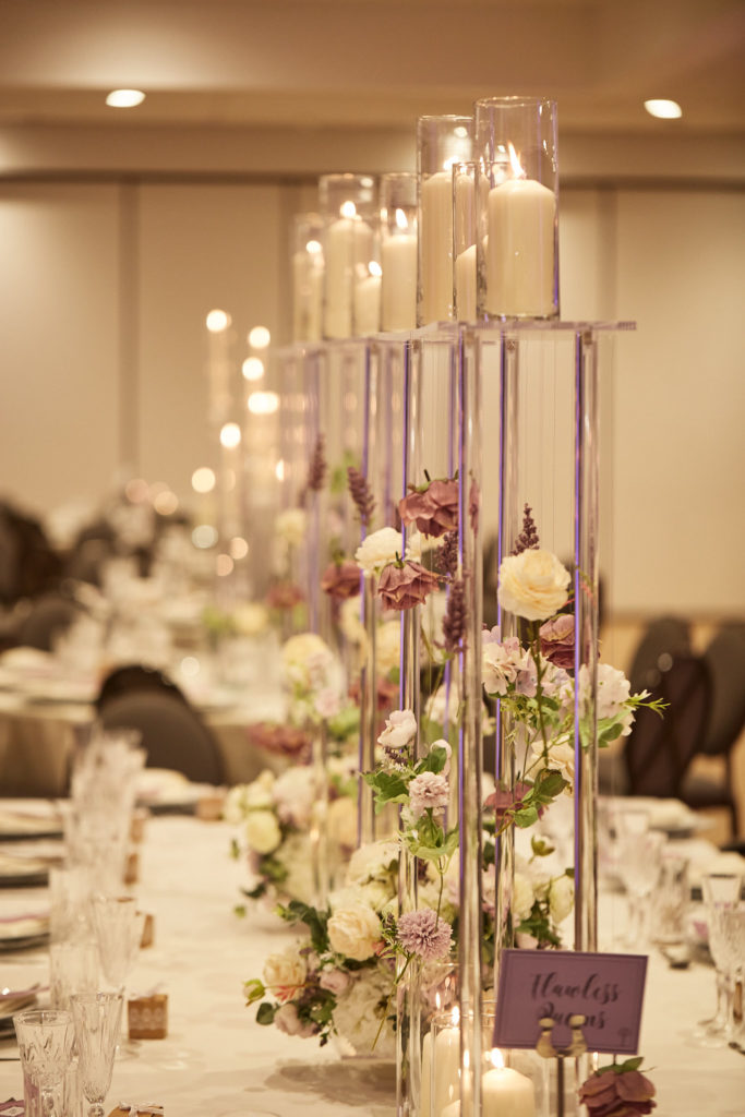 Long table with tall candle stands and trailing flowers