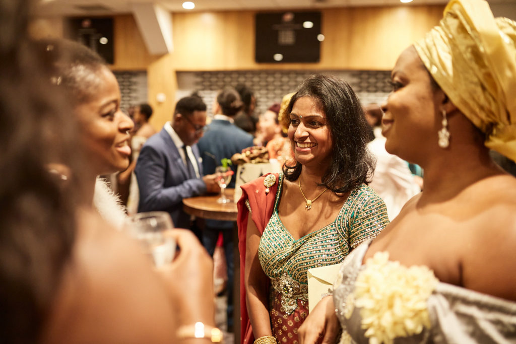 Bride laughing with guests in traditional head ties