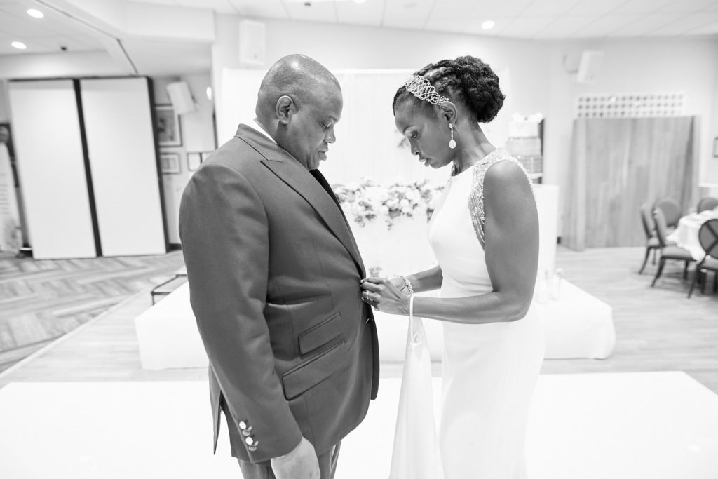 Black and white photo of the bride and groom sharing a quiet moment in the reception room
