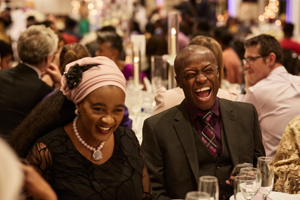 Older wedding guests laughing at their table