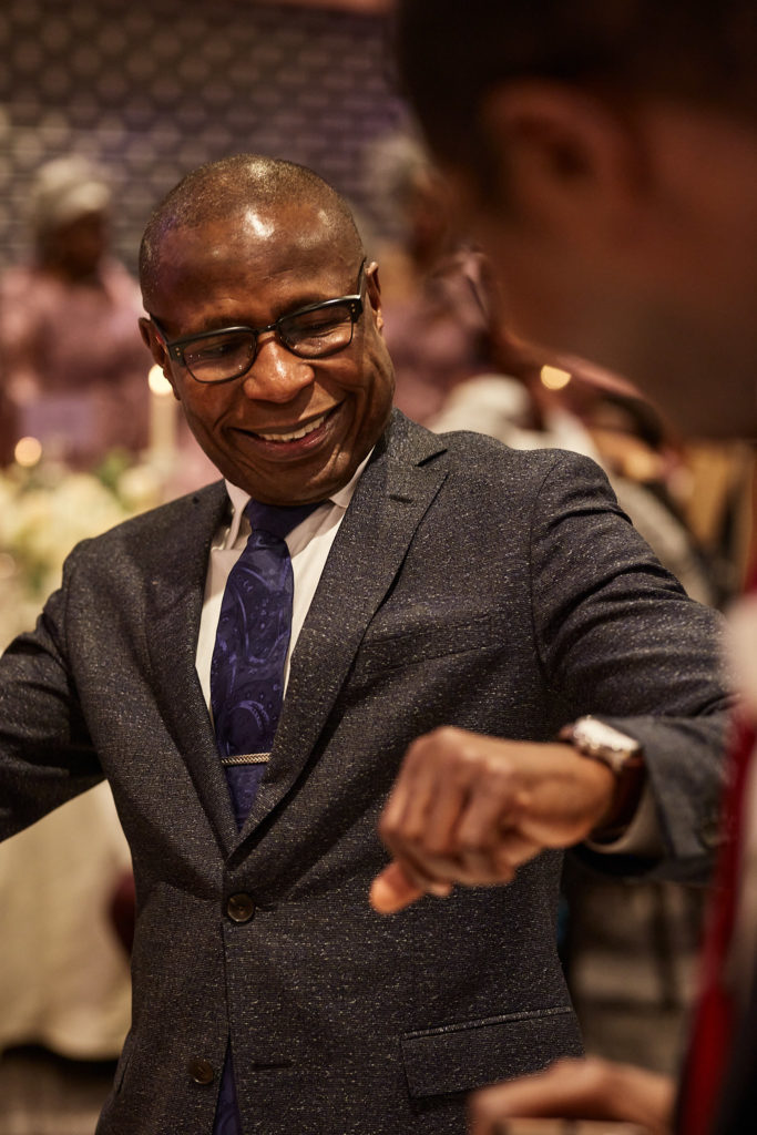 Wedding guest in a grey jacket dancing