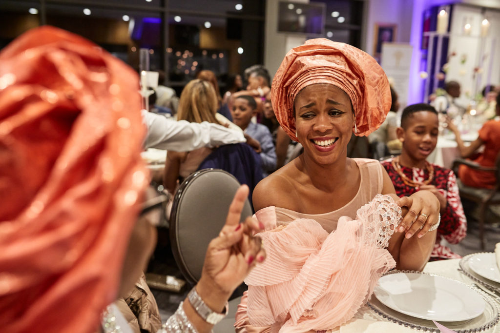 Guest in a pink head tie laughing at the table