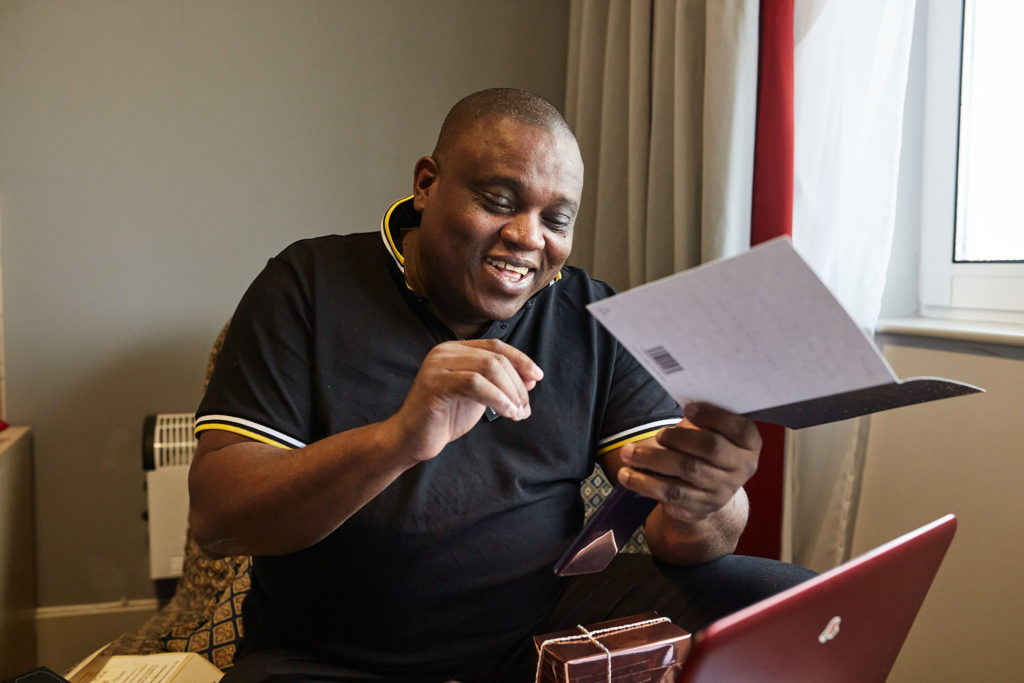 Groom smiling as he reads a card on the wedding morning